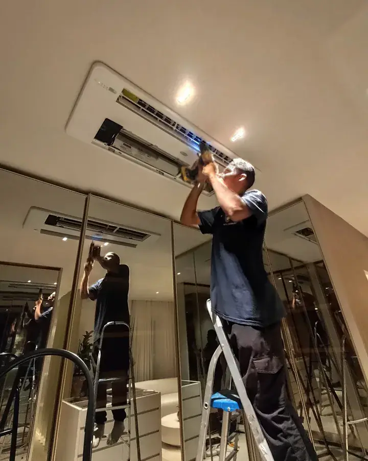 Profissional da equipe trabalhando em um ar-condicionado