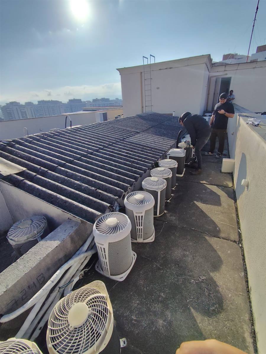 Equipe atendendo vários aparelhos em uma cobertura predial